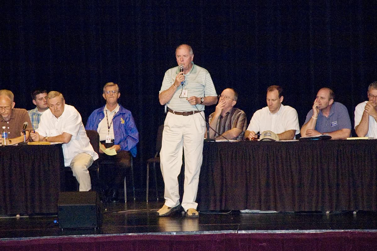 A town hall meeting with a panel on stage